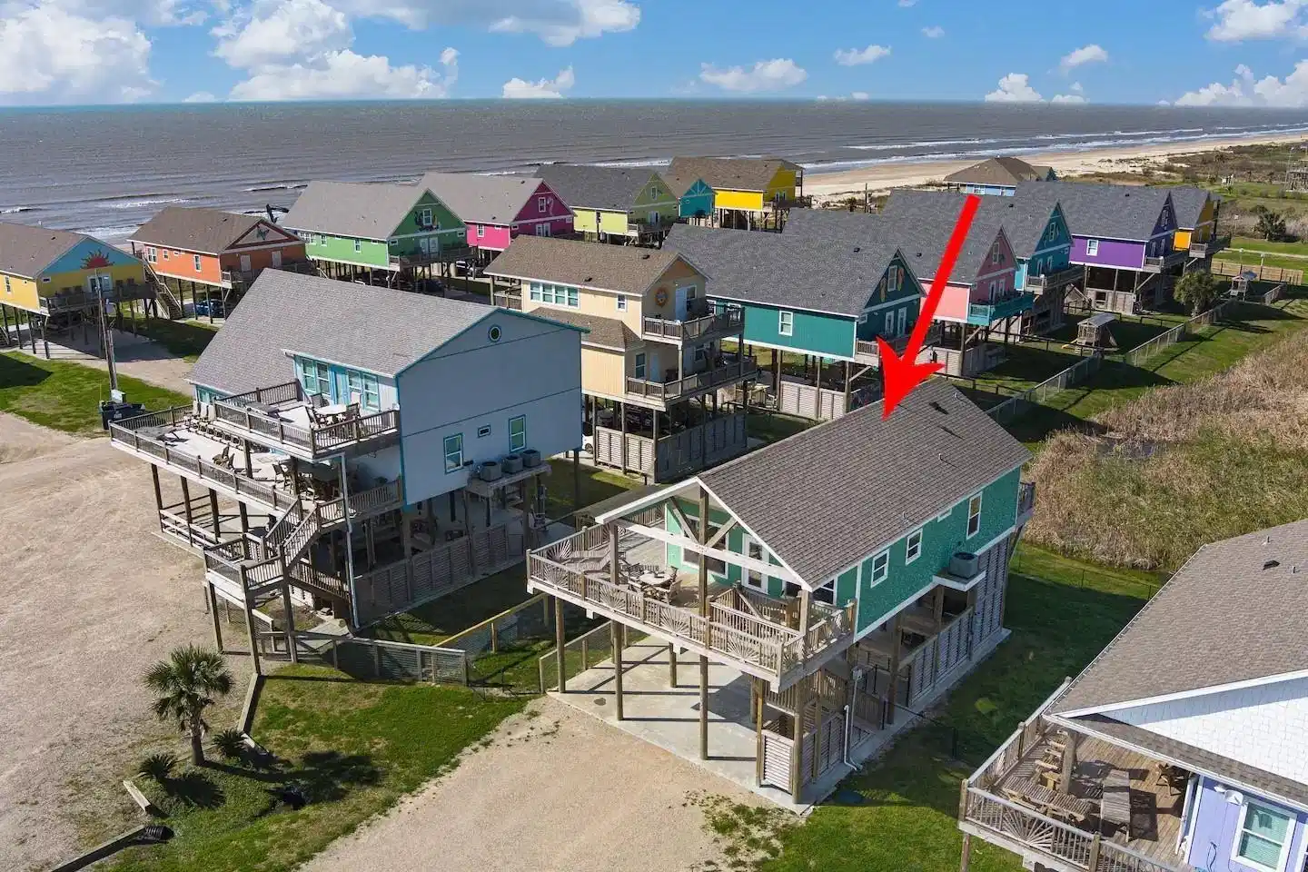 Image 1: Elevated Beach House with vibrant exterior, locate