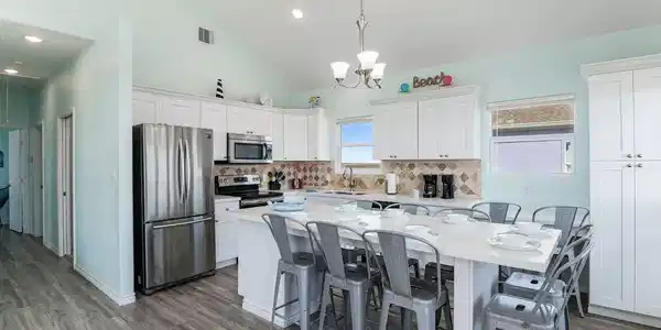 Image 4: Spacious kitchen with vaulted ceilings, featuring