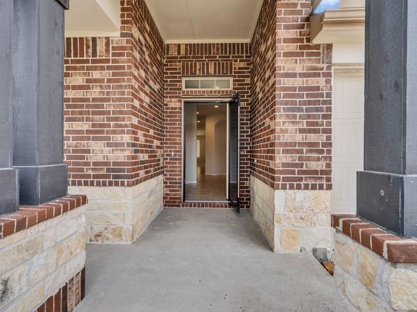 Image 3: Beautiful brick entryway with a covered porch and