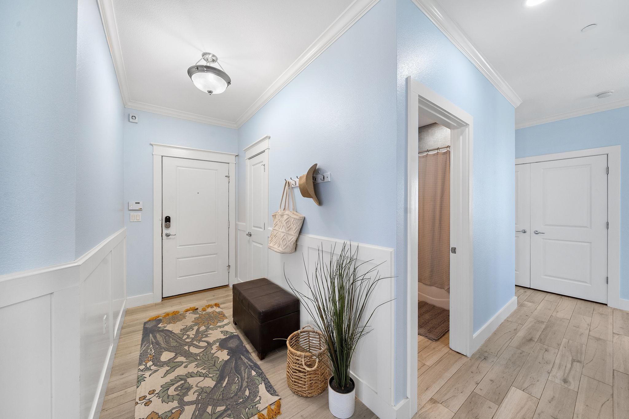 Image 3: This entryway features white wainscoting, decorati