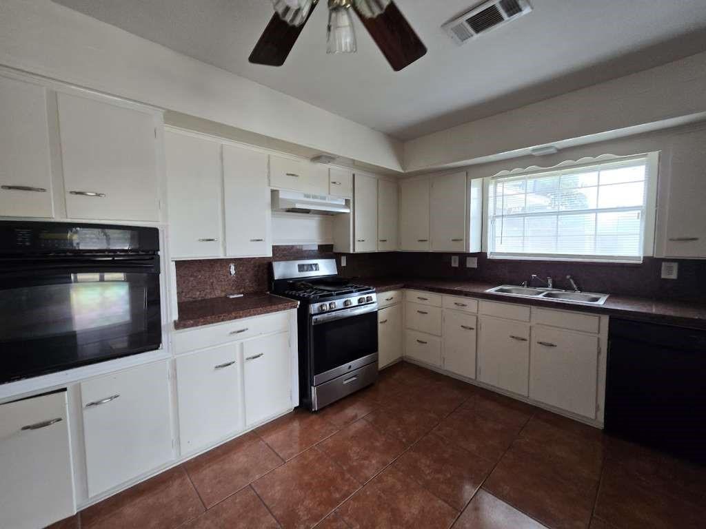 Image 1: This kitchen features ample cabinetry, a large win