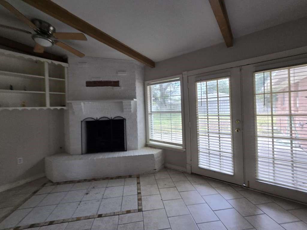 Image 2: Bright living area with large windows and French d