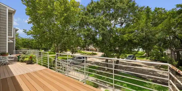 Image 2: A large balcony spans the front of the townhome an