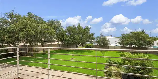 Image 4: The rear balcony overlooks a large greenspace.