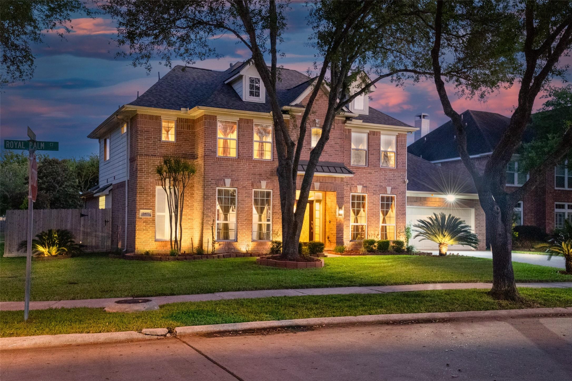 Image 1: Elegant landscape lighting enhances the home's inv