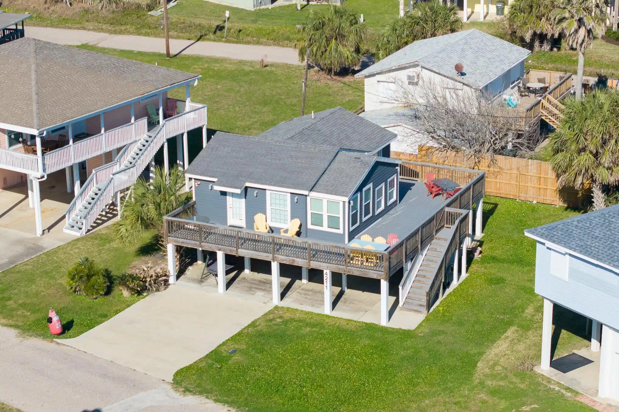 Image 1: This elevated coastal home features a spacious wra