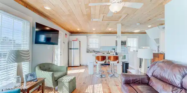 Image 2: Bright, open-concept living with wooden ceiling an
