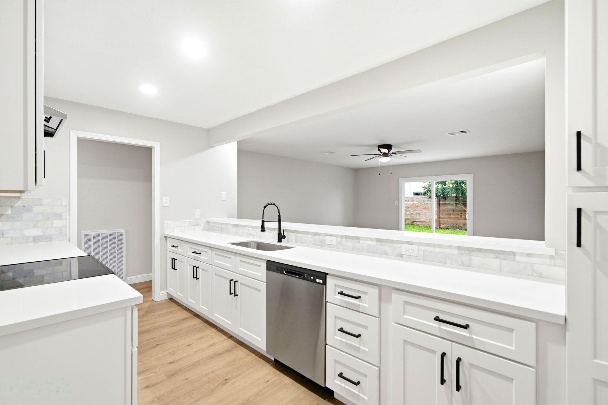 Image 3: The remodeled kitchen opens to the living room