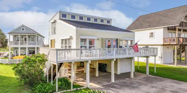 Image 2: This charming home features a wraparound wood deck
