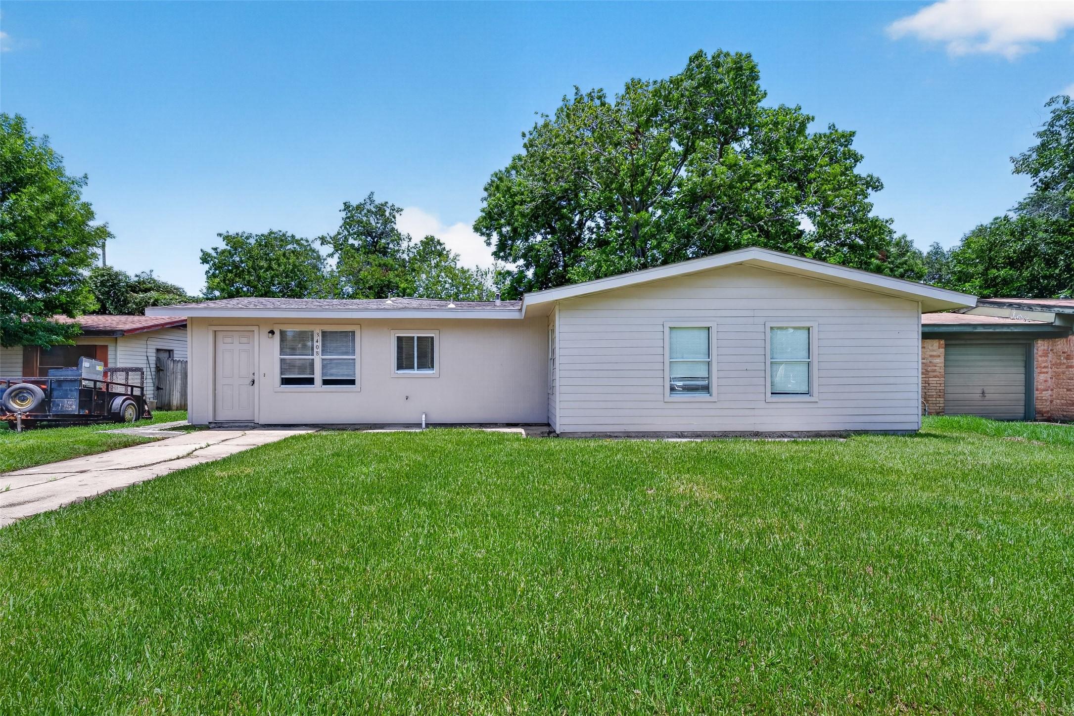 Image 2: Charming single-story home with light siding and a