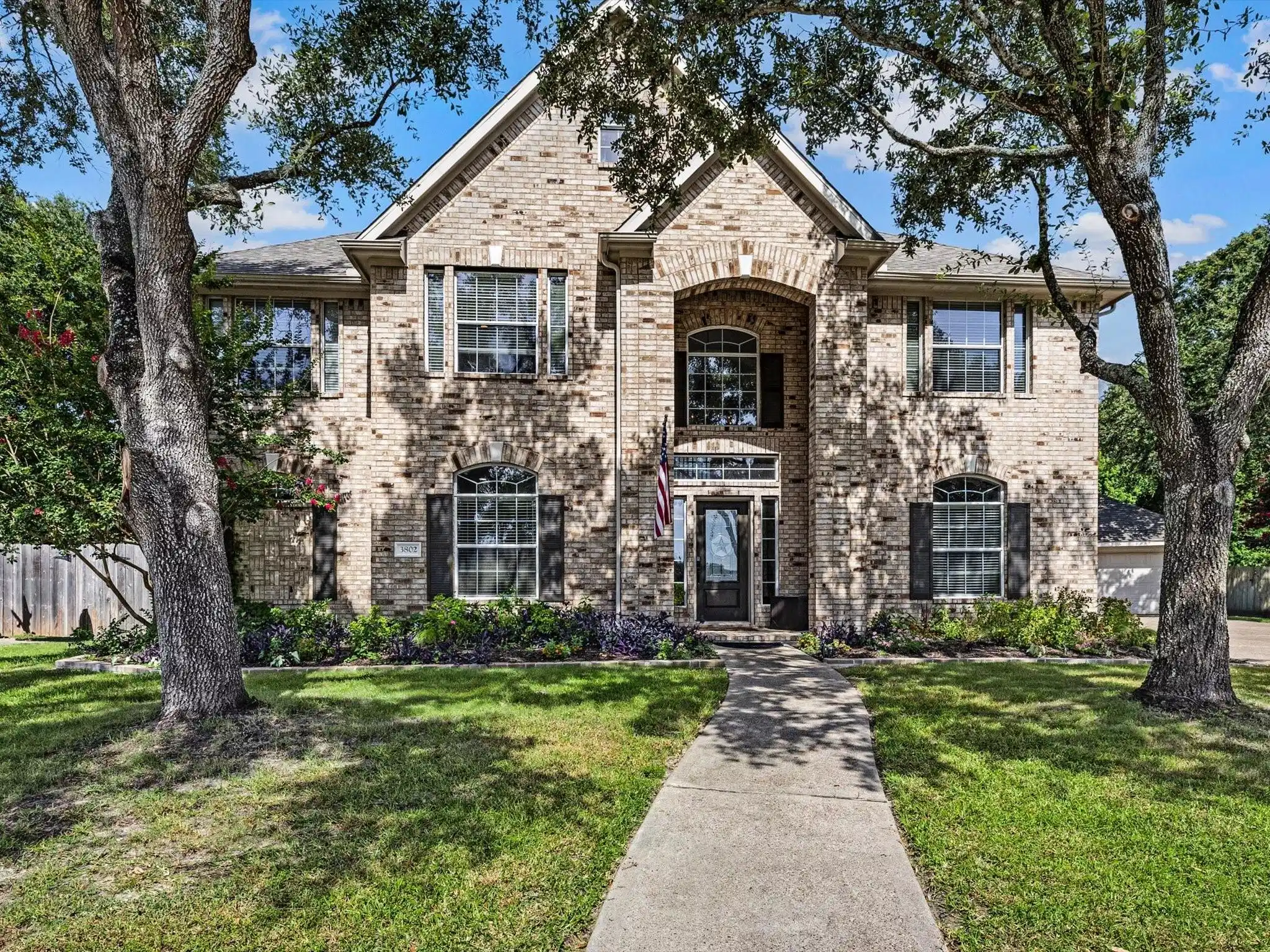 Image 1: Classic brick exterior with professional landscapi