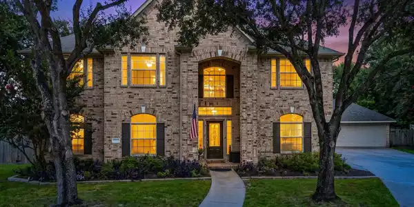Image 2: Beautiful curb appeal with mature oak trees, a gra