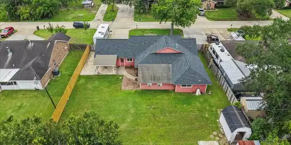 Image 4: Rear aerial view featuring oversized backyard, pat