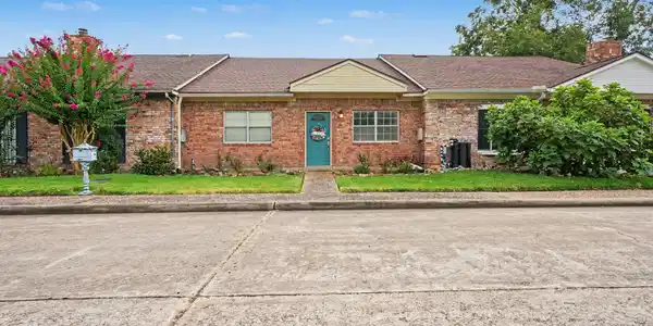 Image 2: Front of townhouse with parking area.