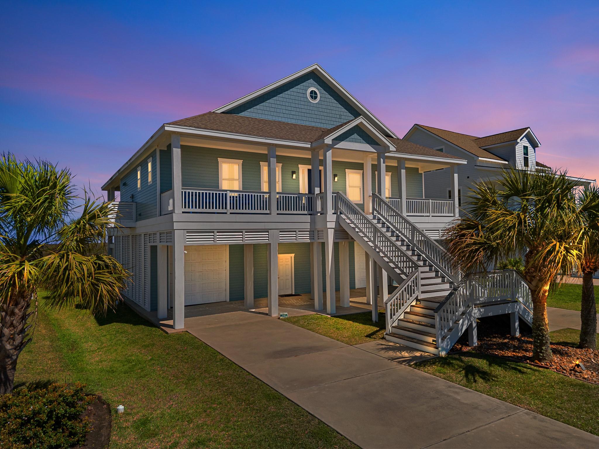 Image 1: Beautifully lit coastal home at sunset, offering w
