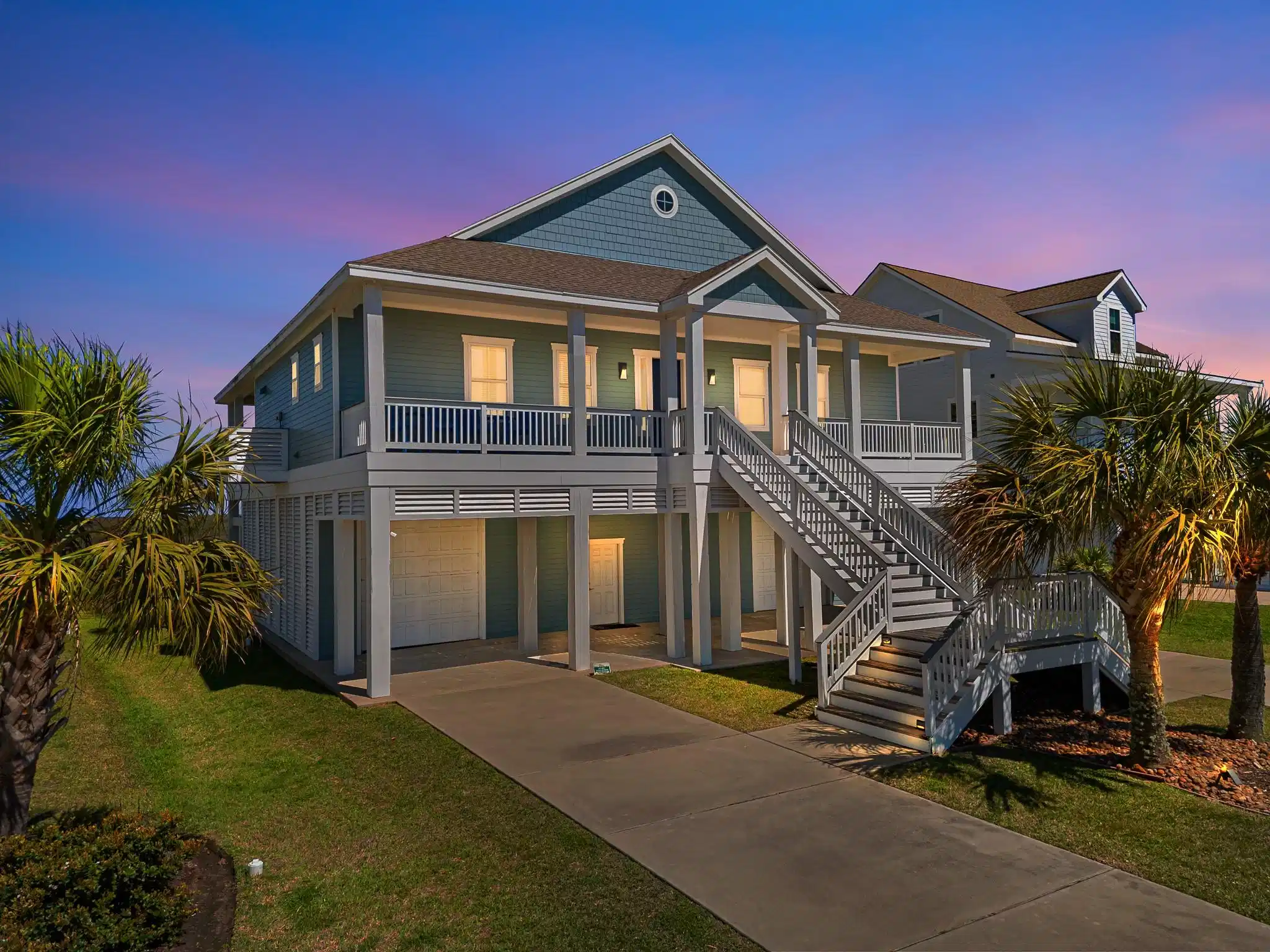 Image 1: Beautifully lit coastal home at sunset, offering w