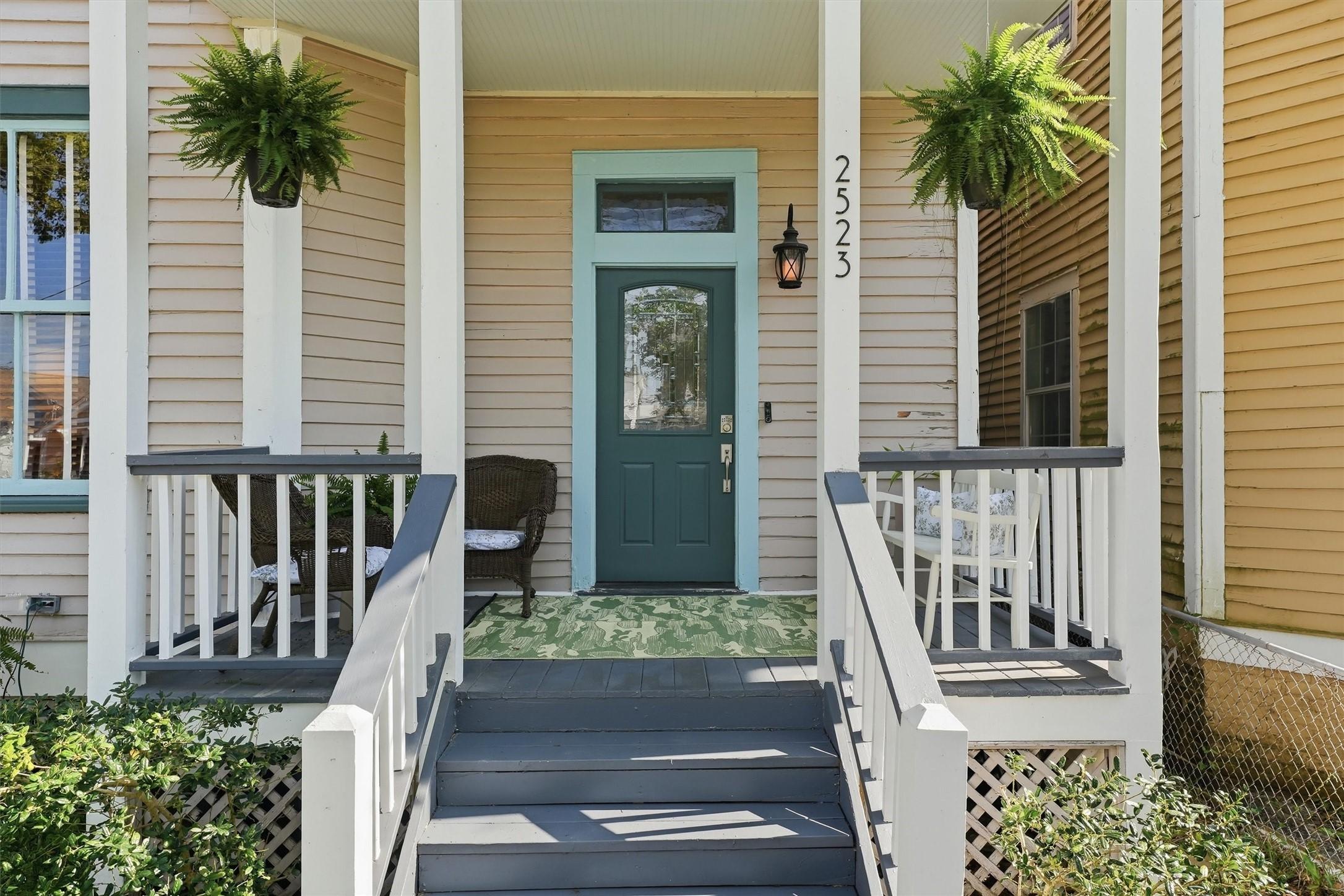 Image 2: Inviting front porch with classic columns and elev