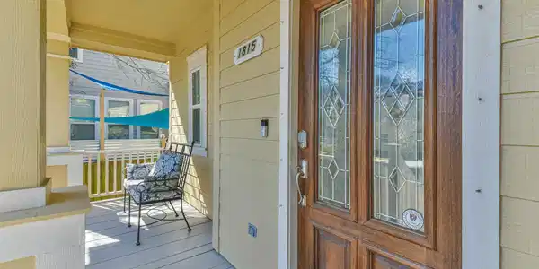 Image 2: Inviting front porch with a stylish wooden door fe