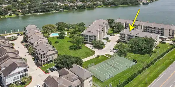 Image 2: Lakeside condo community with lush greenery, a ten
