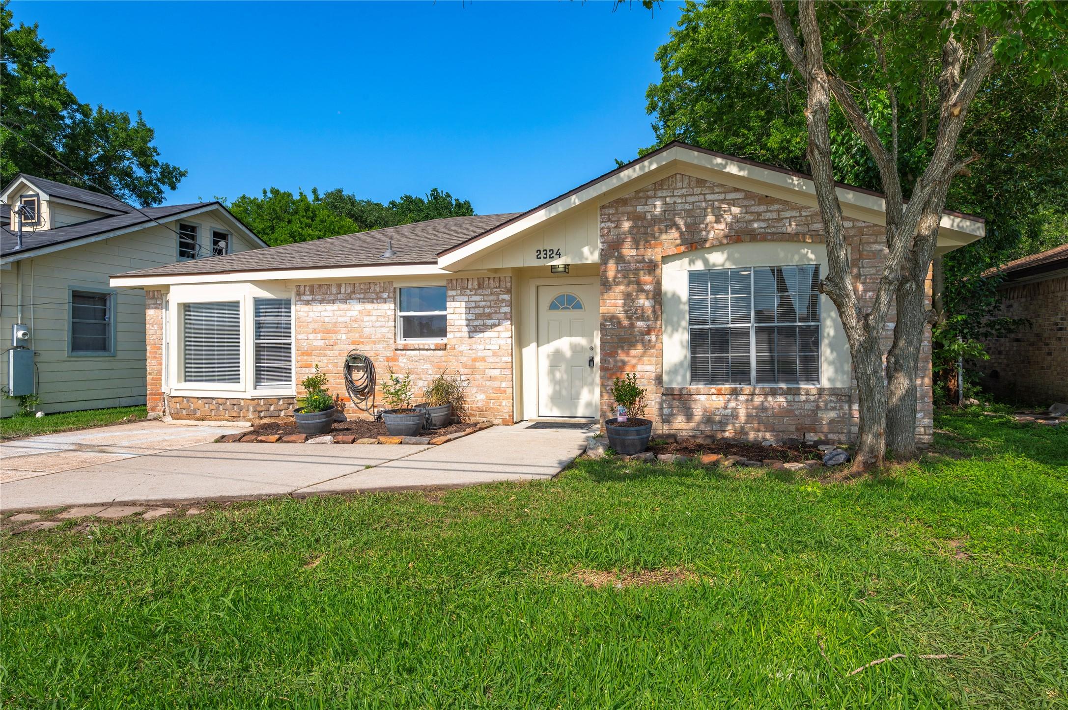 Image 1: Front view of the home with large front yard and g