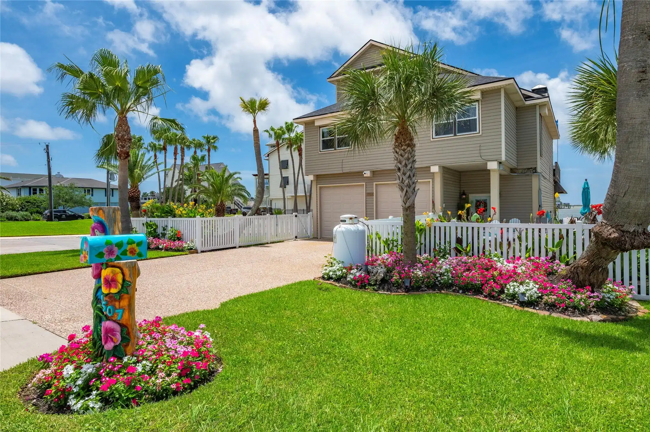 Image 1: Front yard perspective featuring lush lawn, colorf