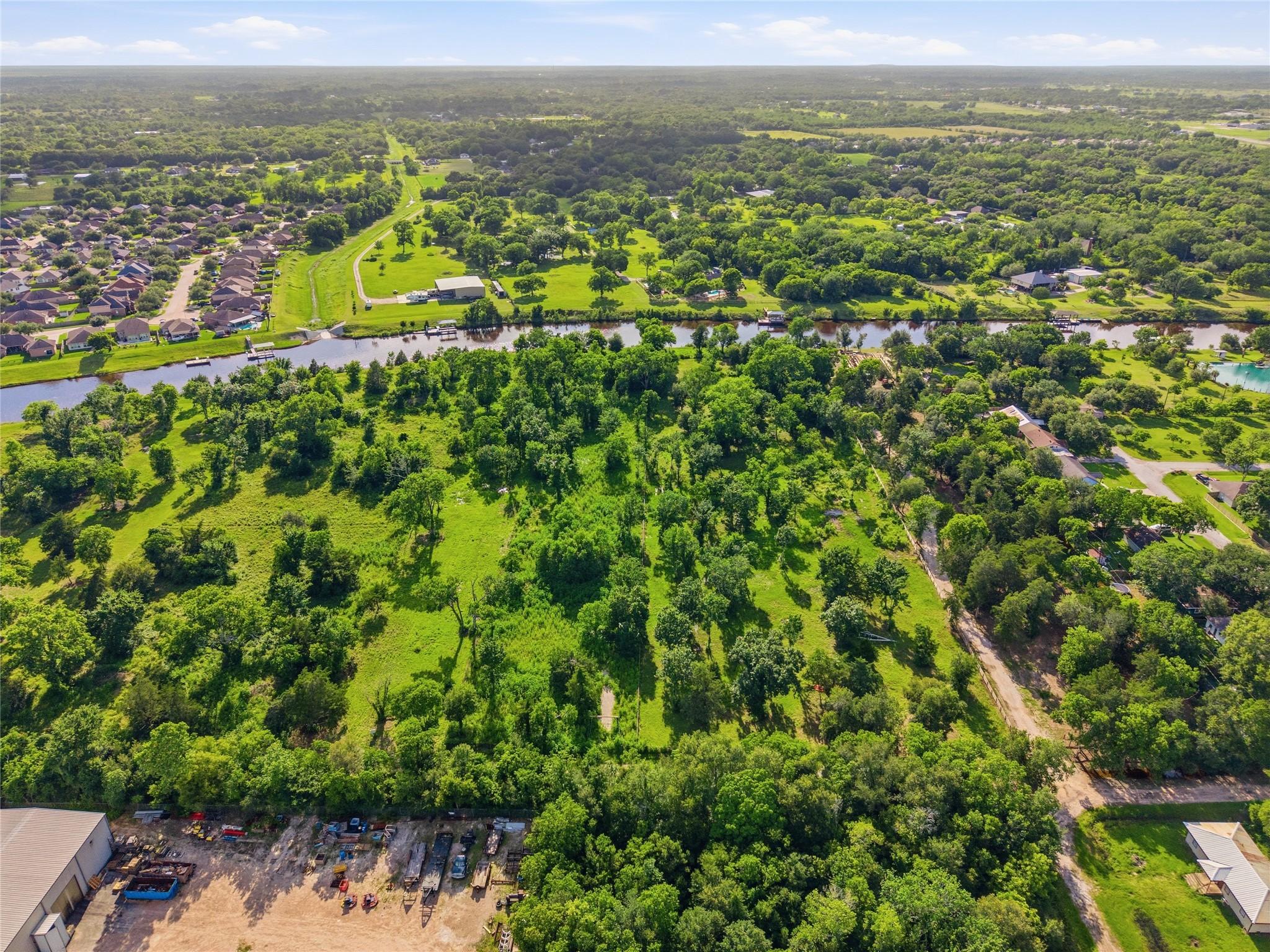Image 3: Spacious, lush green lot bordered by a scenic cana