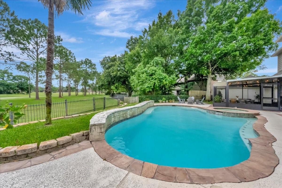 Image 2: This backyard oasis includes a sparkling pool, hot