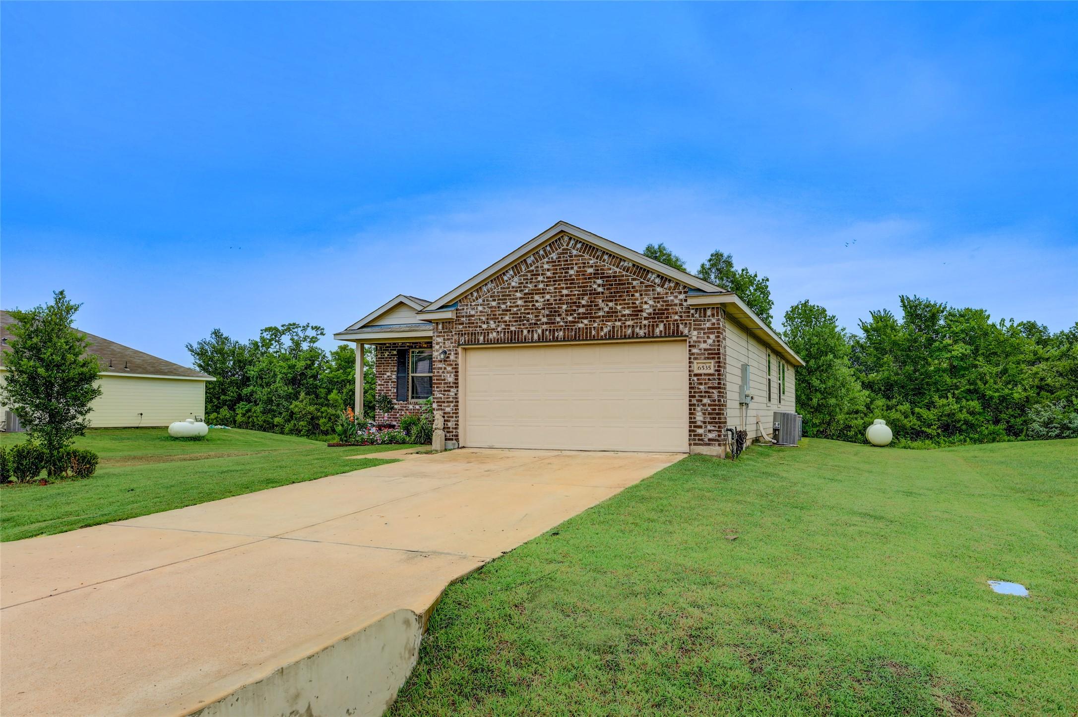 Image 4: The concrete driveway and two-car garage provides