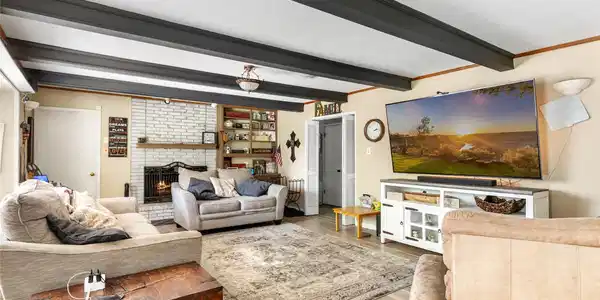 Image 4: Family room features beamed ceiling and cozy firep