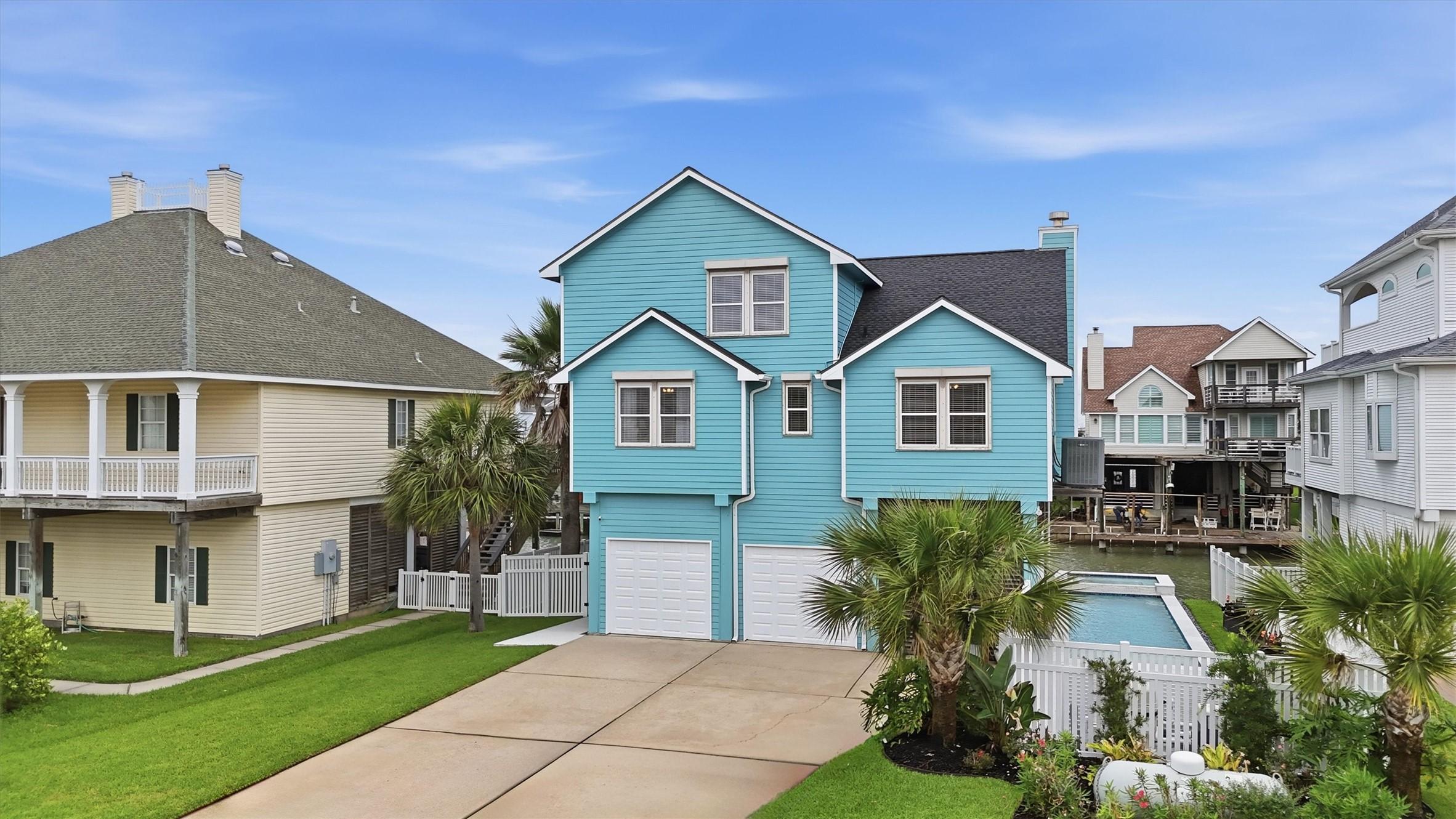 Image 4: Fresh exterior paint, a wide driveway, and a clean