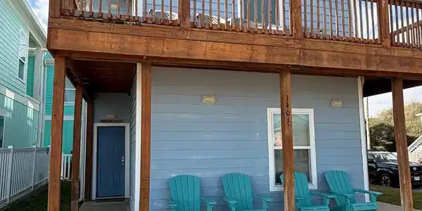 Image 3: This charming two-story home features a light blue