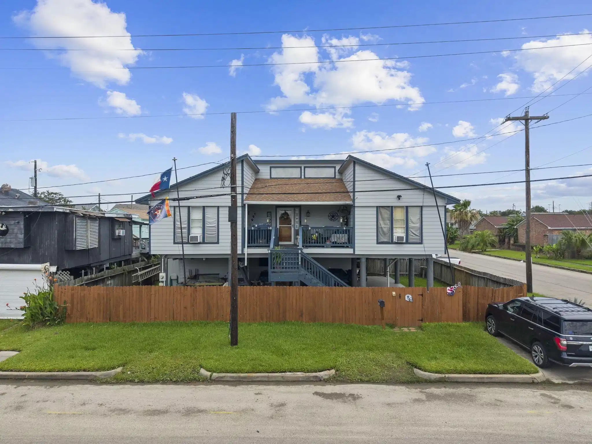 Image 1: Raised, corner lot home with wooden fence and spac