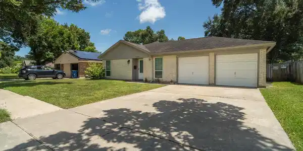 Image 2: Front of home with double wide driveway and many u