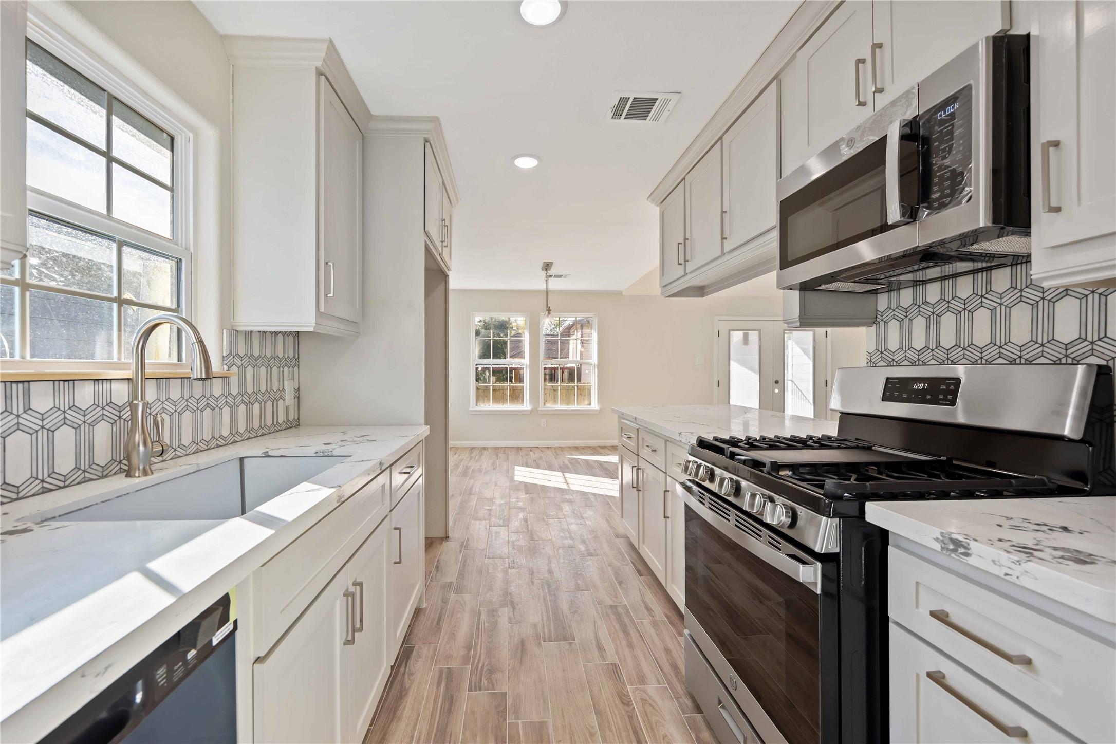 Image 3: Modern kitchen with stainless appliances and marbl