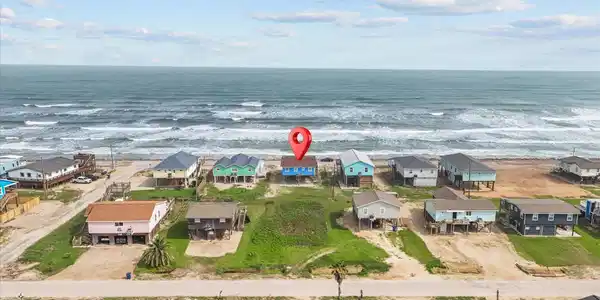 Image 2: This aerial photo showcases a beachfront property