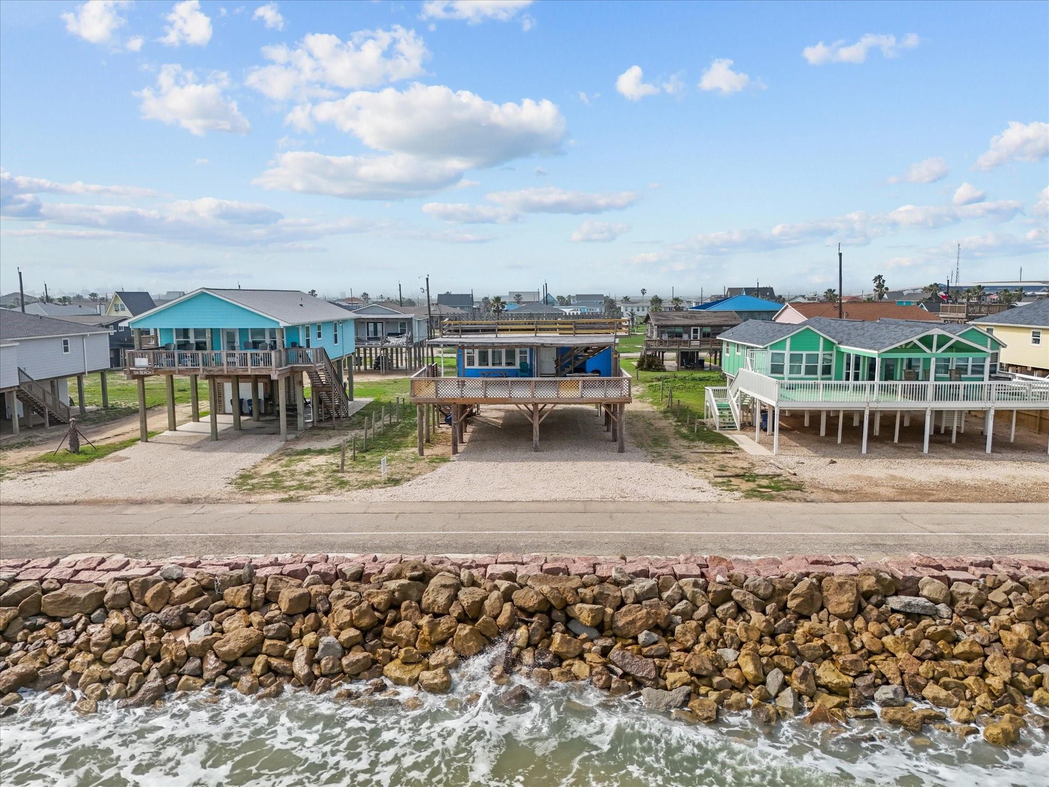 Image 3: Elevated beachfront homes with colorful exteriors,