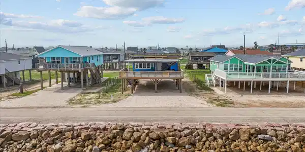 Image 3: Elevated beachfront homes with colorful exteriors,