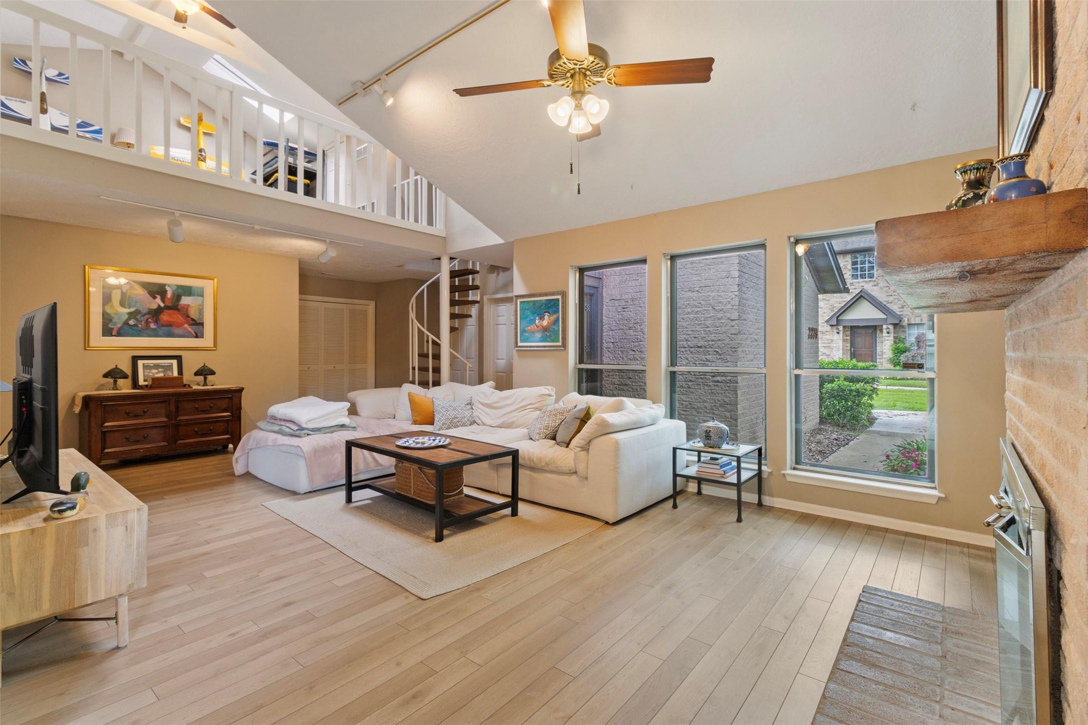 Image 2: This spacious living room features high ceilings a