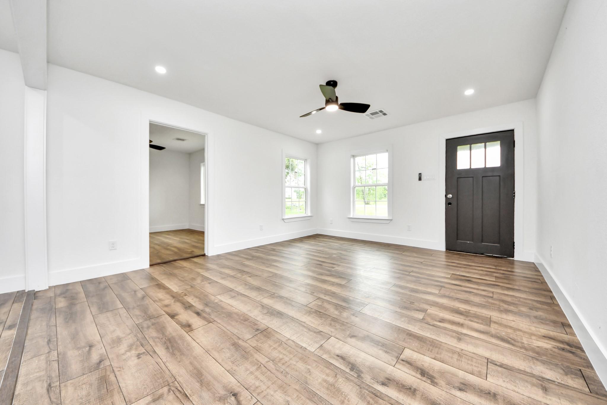 Image 4: Bright, spacious room with wood-style flooring, wh
