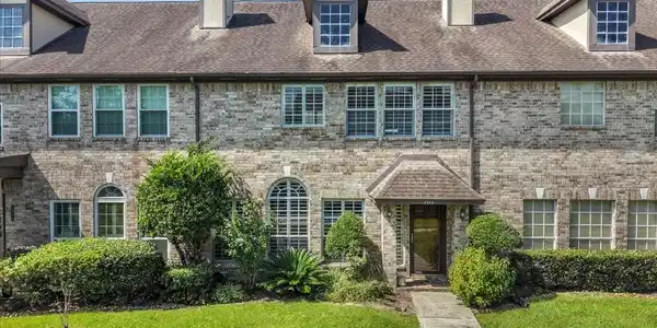 Image 3: Inviting front entrance framed by mature landscapi