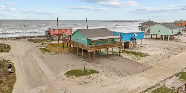Image 2: Elevated beachfront home with vibrant colors, offe