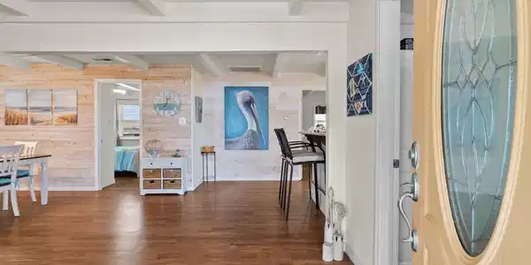 Image 4: Bright and inviting entryway with wooden flooring,