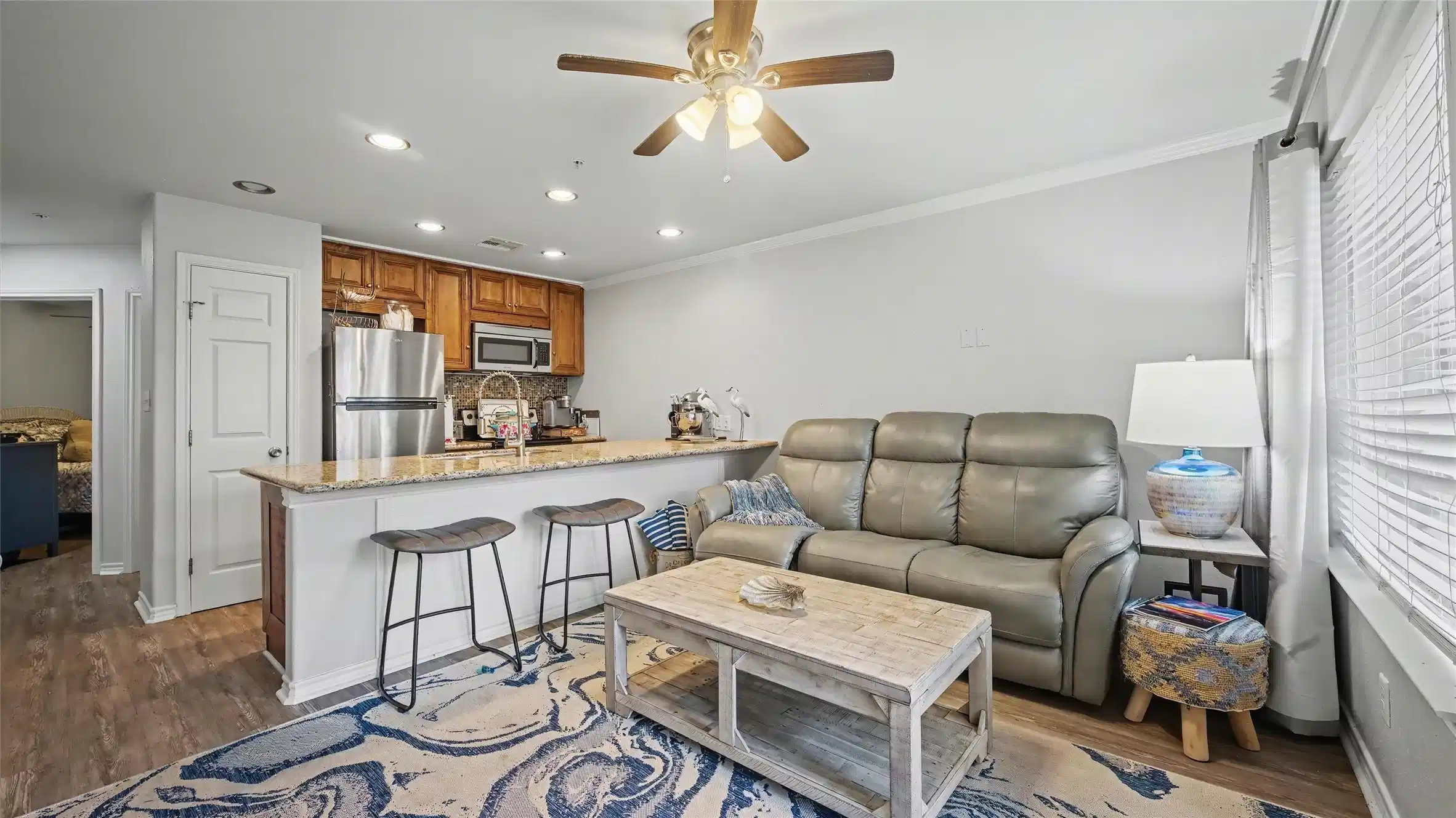 Image 1: Open concept den and kitchen with breakfast bar.
