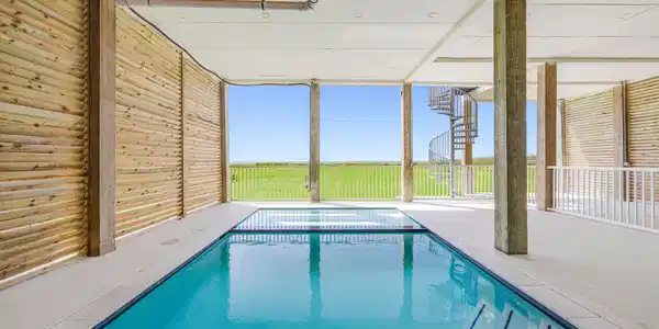 Image 4: A beachfront home with a pool and hot tub. Hard to