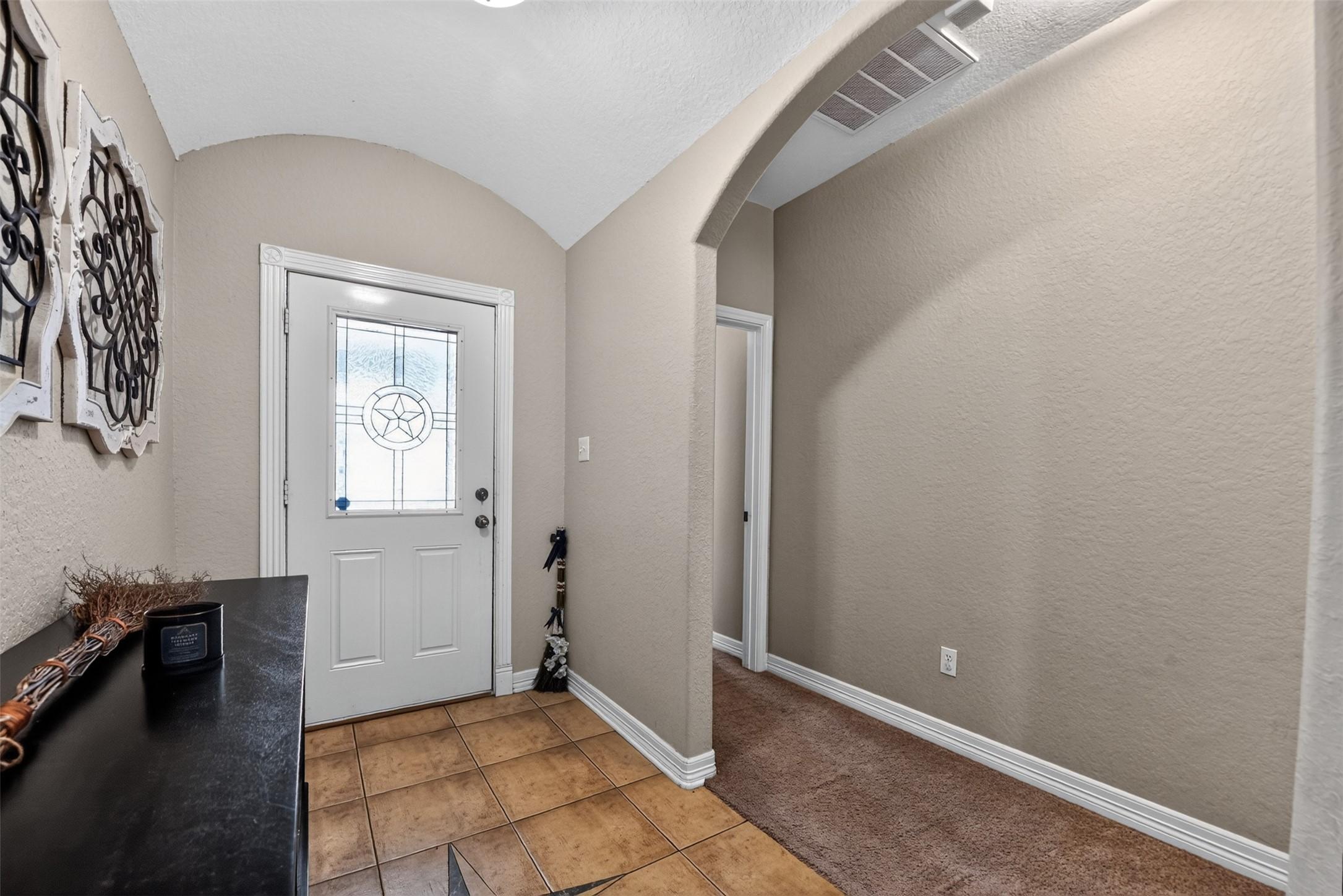 Image 2: Inviting entryway with a stylish front door featur