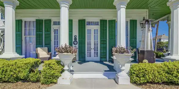 Image 4: Expansive wraparound porch featuring tall windows,