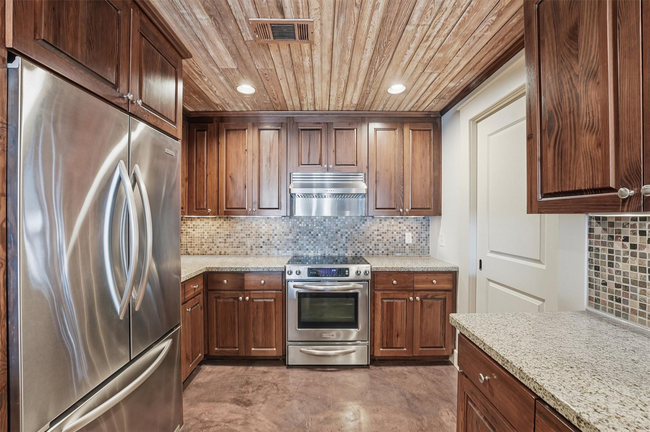 Image 4: The open-concept kitchen features rich wood cabine