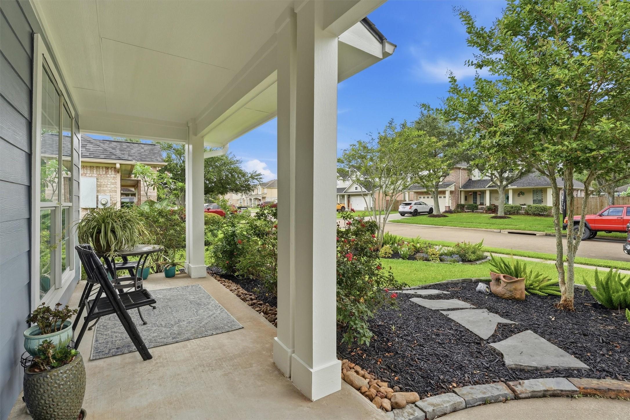 Image 2: Inviting front porch overlooking the landscaped fr