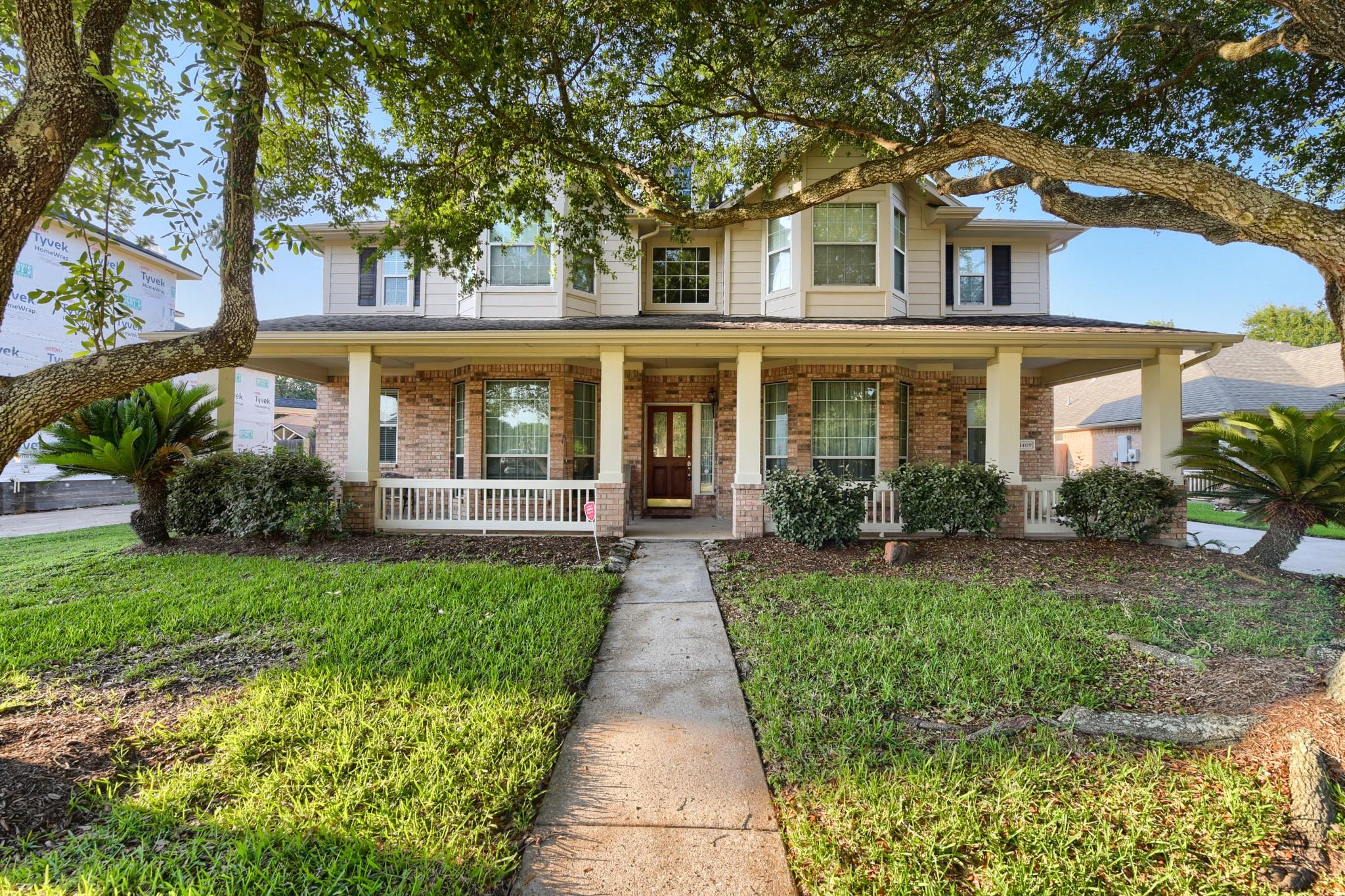 Image 2: Mature trees grace the property with a covered fro