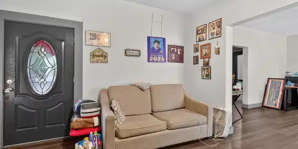 Image 3: Entryway and living room displaying a front door w